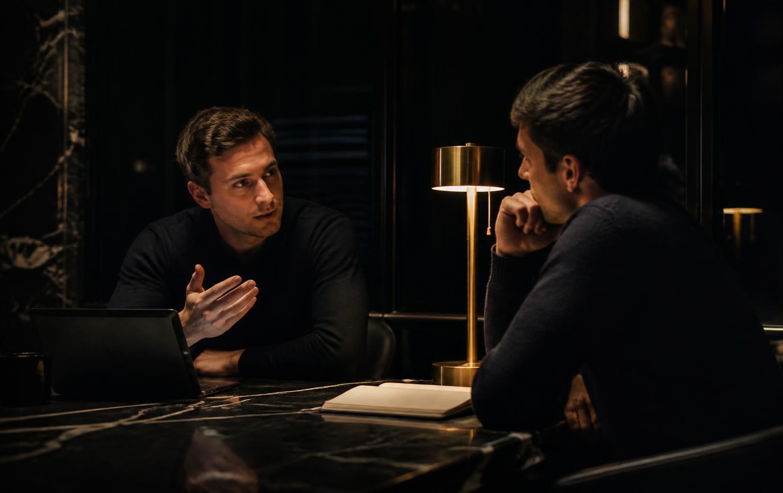 Two founders in conversation at a table